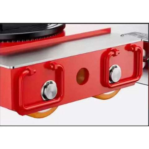 Close-up of the red motorized machinery dolly's durable structure, showcasing pivot turntable, wheels, and connection points.