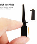 Close-up of a black insulated test hook probe with a built-in spring and finger pressing, part of Test Hook Probe Kit For Digital Multimeter Leads With Safe Insulated Plastic Boots Round Test Hooks And Mini Clips That Grip Tiny Components Tight Powerful Spring Tension Keeps Contacts Secure And Short Free.