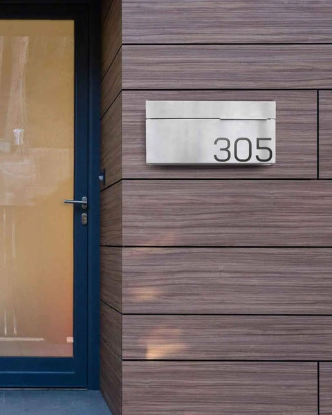 Modern Wall Mounted Home Mailbox In Stainless Steel Rust Resistant Weatherproof on wooden panel wall next to a door