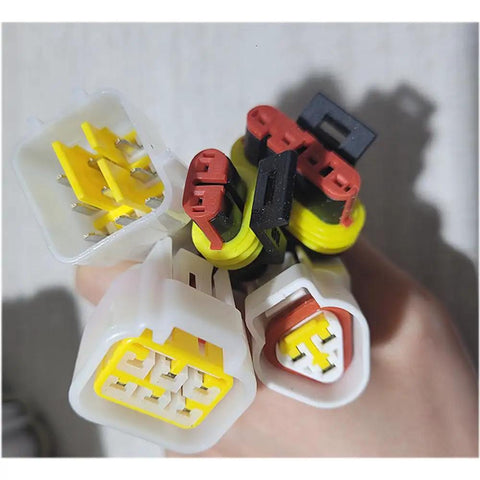 Heavy Duty EV Car Controller For 48V 60V 72V AC Motor Drives connectors in hand, showcasing various sizes and colors for universal fit.