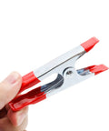 Rock Solid Four Inch Metal Spring Clamps With Grippy Rubber Tips held in hand, showcasing shiny metal and red rubber tips.