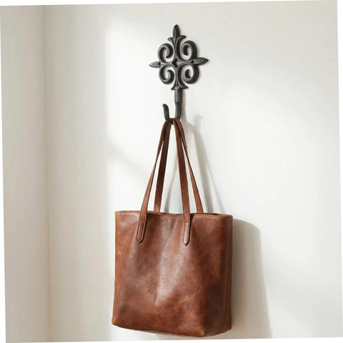 Rock Solid Cast Iron Wall Hook Knockout Vintage Charm For Entryway And Master Bedroom Bullet Proof Heavy Duty Towel And Coat Rack Dead Simple No Sweat Installation In Matte Black Finish With Screws Included Now, holding a brown tote bag.