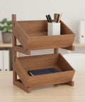 Two Tier Wooden Storage Shelf With Tilted Open Trays Walnut Finish Floor Standing Organizer Rack Minimalist Design with pens and notebook.