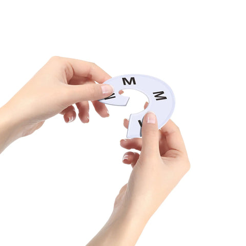Person holding 40 Pack Round White Plastic Closet Rack Dividers, size M, showing durable PVC material and preprinted sizes for easy organization.