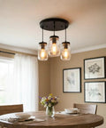 Industrial Mason Jar Pendant Lights for Kitchen Island above dining table with flowers, modern farmhouse style.