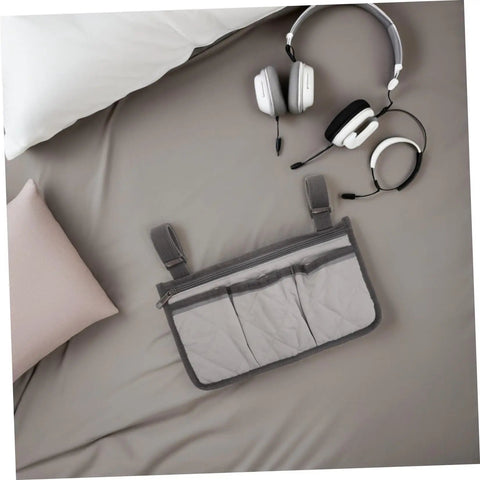 Senior Bedside Rail Organizer With Four Compartments And Cup Holder, Pongee Storage Bag on bed with headphone nearby.
