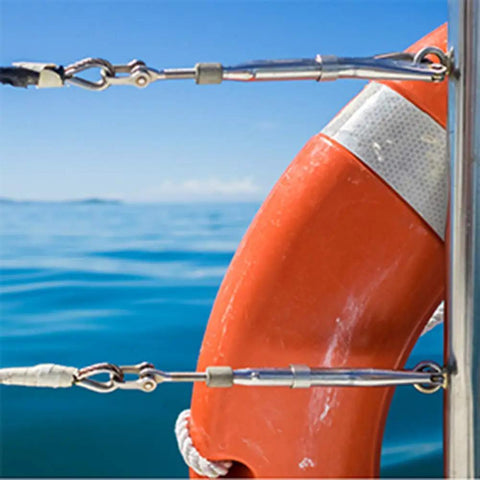 Boat railing with rope and cable fittings, stainless steel hardware against ocean background