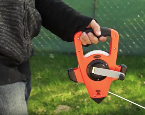 Person using NRS18M330 Nylon Reinforced Tape Measure With Beast Speed Rewind And Double Hook 100M 330FT outdoors