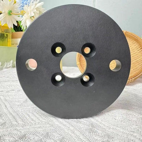 Rock Solid Self Centering CNC Vise Tailored For 4 And 5 Axis Milling showing the round black base with multiple holes for precision clamping.