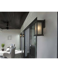 Endicott Collection 1-Light Outdoor Wall Lantern in Antique Bronze with Etched Umber Linen Glass on porch wall