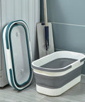 Collapsible Rolling Bucket With Four Wheels 12L Mop Bucket For Home Cleaning Camping And RV Lightweight Portable Multi Purpose Rectangular Handy Basket For Mop And Laundry Gray, folded and unfolded beside mop
