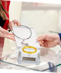 Galpada Solar Powered Jewelry Display Stand With Electric Rotating Turntable For Bracelets And Watches Plus Earrings Store Office Counter Shelf Rack Natural Light Battery Backup Smooth Spin Showcase displaying a gold bracelet and a necklace.