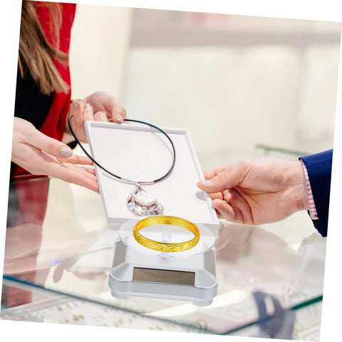 Galpada Solar Powered Jewelry Display Stand With Electric Rotating Turntable For Bracelets And Watches Plus Earrings Store Office Counter Shelf Rack Natural Light Battery Backup Smooth Spin Showcase displaying a gold bracelet and a necklace.