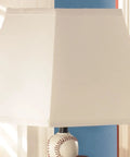 Sports Fan Youth Table Lamp 24 Inch Baseball And Football Athletic Desk Lamp In Brown And Orange, Sturdy Polyresin Base, Perfect Nightstand Light For Kids Bedroom And Study with a white square fabric shade and baseball-designed base.