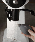Hand using Air Blower Dust Cleaner Tool For Coffee Grinders Cameras Keyboards And Watches With Silicone Body And Stainless Steel Nozzle