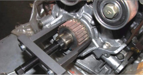 In-use view of RSYEKU two-jaw adjustable steel bearing puller removing a gear from a shaft (30–90 mm)