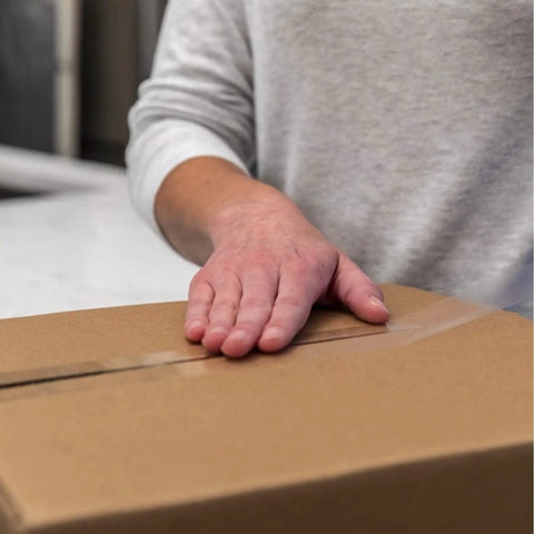 Person sealing a box with High Performance Clear Packing Tape Refills, 8 Rolls Of HP260 Heavy Duty Packaging Tape For Shipping, 3 Inch Core
