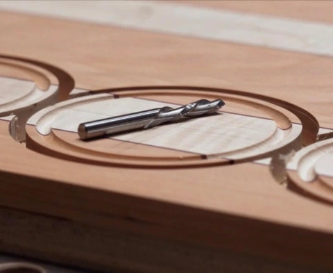 Close-up of wood with precise circle cuts using Pro Circle Cutting Router Jig, Polycarbonate Precision Tool For Woodworking.