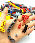 Hand holding pieces from Tech Build Kit With 420 Pieces Technic Beams Axles Connectors And Brick Parts For STEM Car Builds Frame Liftarms Set