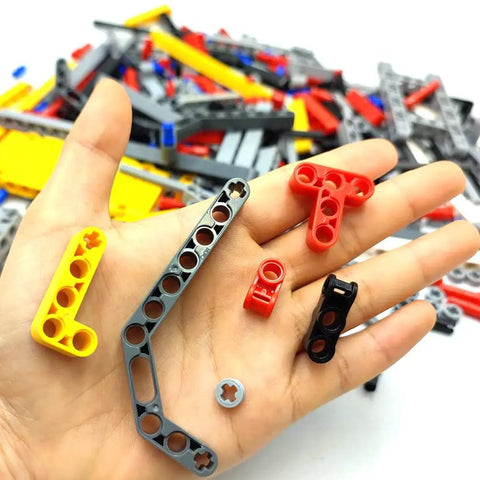 Hand holding pieces from Tech Build Kit With 420 Pieces Technic Beams Axles Connectors And Brick Parts For STEM Car Builds Frame Liftarms Set