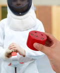 Person holding fencing gear tester box for foil and epee training and gear repair with beeping sensor in red.