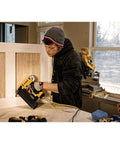 Professional 18 Gauge Brad Nailer With Rear Exhaust Blasts Dust Away Tight Trigger used by a carpenter assembling wood panels.