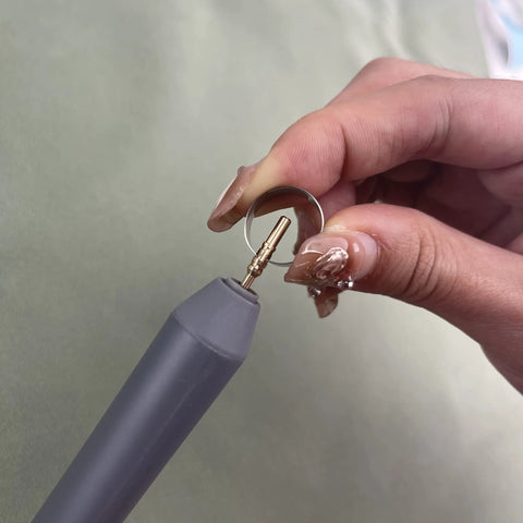 Grey foil quill pen starter kit with brass tip; close-up of tip held in hand.