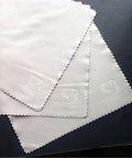 White microfiber cleaning cloths with brand logo on a dark background.