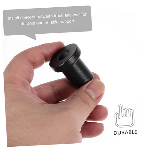 Hand holding a black spacer from the Carbon Steel Sliding Barn Door Track Spacers Kit 4 Pack Durable Wall Mount Connectors For Barn Door Hardware Easy Install Rock Solid Rail Support For Garage Basement Or Home Sliding Doors.
