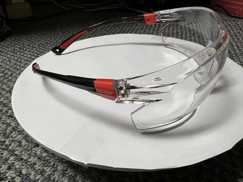 Lightweight Safety Glasses With Adjustable Arms And Soft Nose Pad Built For All Day Comfort Eye Protection Anti Fog Scratch Resistant And Shatter Proof ANSI Z87 EN 166 Certified Comes With Carrying Case displayed on a white background.