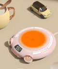 Keep Your Brew Sizzling On Your Sweet Desk Setup With This Aluminum Alloy Cup Warmer Featuring Three Heat Levels And Integrated Auto Shutoff Safety Up To 167 Fahrenheit For Cozy Mornings And Lowkey Amazing Office Vibes In Classic Pink, showing mini electric cup warmer with orange heating plate.