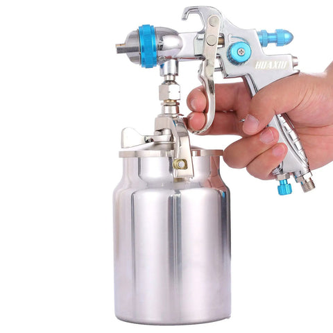 Hand holding Professional HVLP Siphon Feed Spray Gun With 1000cc Non Drip Cup One Point Seven Millimeter Nozzle Fully Adjustable Fluid Pattern And Air Controls Wide Fan Pattern Easy Maintenance Pro Grade Coating For Slick Showroom Ready Finishes
