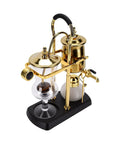 Artisan Manual Siphon Coffee Maker Featuring Sturdy Heatproof Glass Carafe in gold and black on kitchen counter.