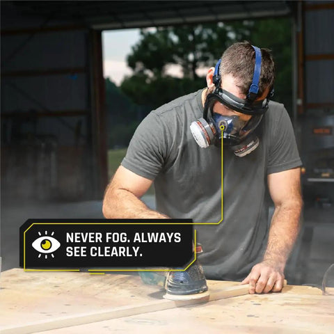Worker using Workhorse Full Face Respirator Mask for Work and Survival, with anti-fog polycarbonate lens in a dusty workshop.