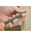 Close-up of hand using Top Tier Spring Loaded Nail Setter Punch With Slick Alignment Build and Hustle Ready Grip on wood surface.