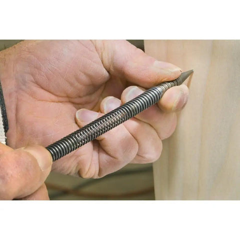 Close-up of hand using Top Tier Spring Loaded Nail Setter Punch With Slick Alignment Build and Hustle Ready Grip on wood surface.