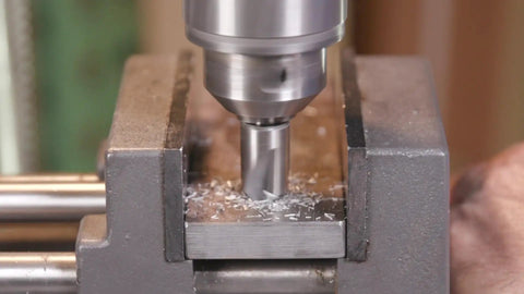 3/8 Inch 90 Degree High Speed Steel Chatterless Countersink Featuring Six Precision Flutes in use on steel surface with shavings.