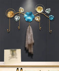 Rock Tight Wrought Iron Wall Hook For Sleek Nordic Style And Snug Door Storage That Locks In Keys Bags And Jackets Without A Sweat While Serving Heavy Duty Swag On Your Front Porch, featuring gold and blue decorative leaves.