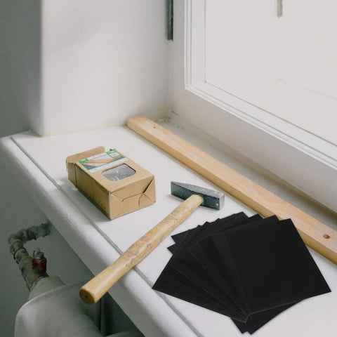 Nine Sheets Wet Dry Sandpaper Assortment With Grits 60 To 320 for woodworking on a windowsill with a hammer and wood.