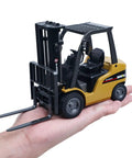 Mini Warehouse RC Forklift Model 9925 With Realistic Light And Sound Effects Precise Steering Lift Lower Function Plus Remote Control Operation For Indoor Play held in a hand.