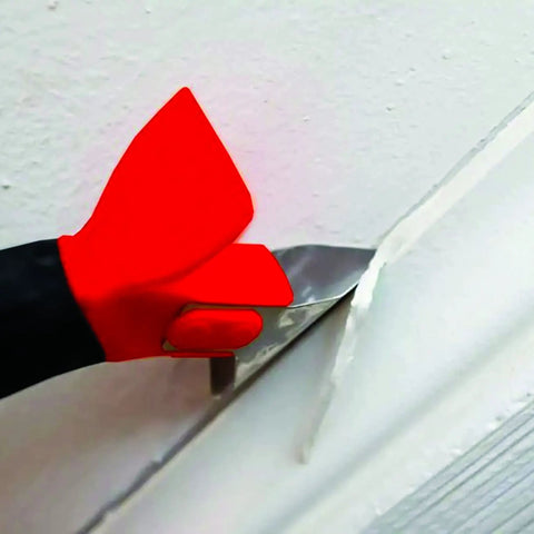 Close-up of Three In One Caulk Tool For Removal And Application With Soft Grip Handle showing stainless steel blade in use.