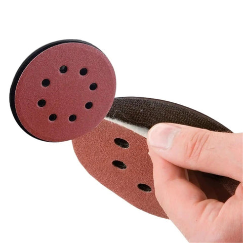 50 Piece 5 Inch Sanding Discs with Eight Holes for Rock Solid Wood Metal Paint Smoothing, showing tactile hand grip on disc.