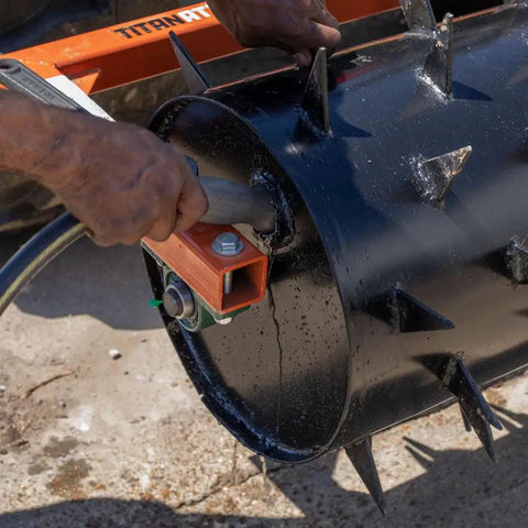 Close-up of Six Foot Drum Spike Aerator For 3 Point Hitch On Cat 1 And Cat 2 Tractors showing spikes and water hose attachment.
