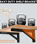 Heavy Duty Folding Shelf Brackets 12 Inch 2 Pack Wall Mounted Drop Down Table For Home Or Workspace Space Saving Counter Supports 400 Pounds Black With Rock Solid Hinge with kettlebells on a wooden shelf.