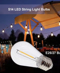 25 Pack Replacement LED Bulbs For S14 String Lights Shatterproof Waterproof 1 Watt Equivalent To 11 Watt Incandescent Warm White 2700K E26 Medium Base Non Dimmable, bulb shown with outdoor string lights