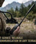 Person holding handheld radio with Beefy Dual Band Ham Radio Antenna For VHF UHF 136 To 174 MHz And 400 To 470 MHz in outdoor setting.