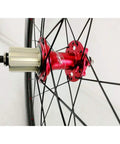 Close-up of red 7075 aluminum hub on 700C Road Carbon Fiber Fat Ring Disc Brake Wheel Set, showing spoke attachment.