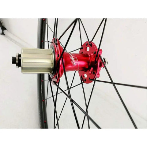 Close-up of red 7075 aluminum hub on 700C Road Carbon Fiber Fat Ring Disc Brake Wheel Set, showing spoke attachment.