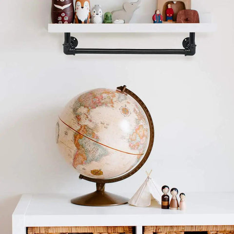 Wall-mounted black malleable iron pipe coupling shelf with colorful toys, part of industrial DIY shelving and furniture setup.