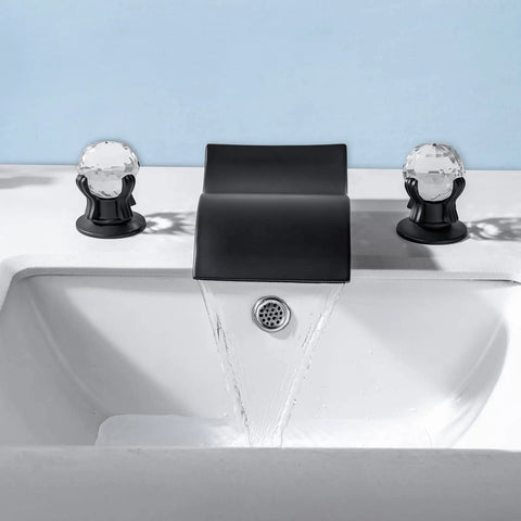 Widespread Matte Black Bathroom Sink Faucet With Crystal Knobs, Two Handles, Wide Waterfall Spout, shown on white basin
